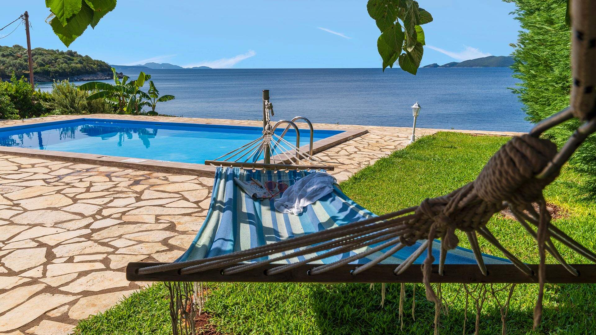 Hangmat blauw aan zwembad met uitzicht op zee