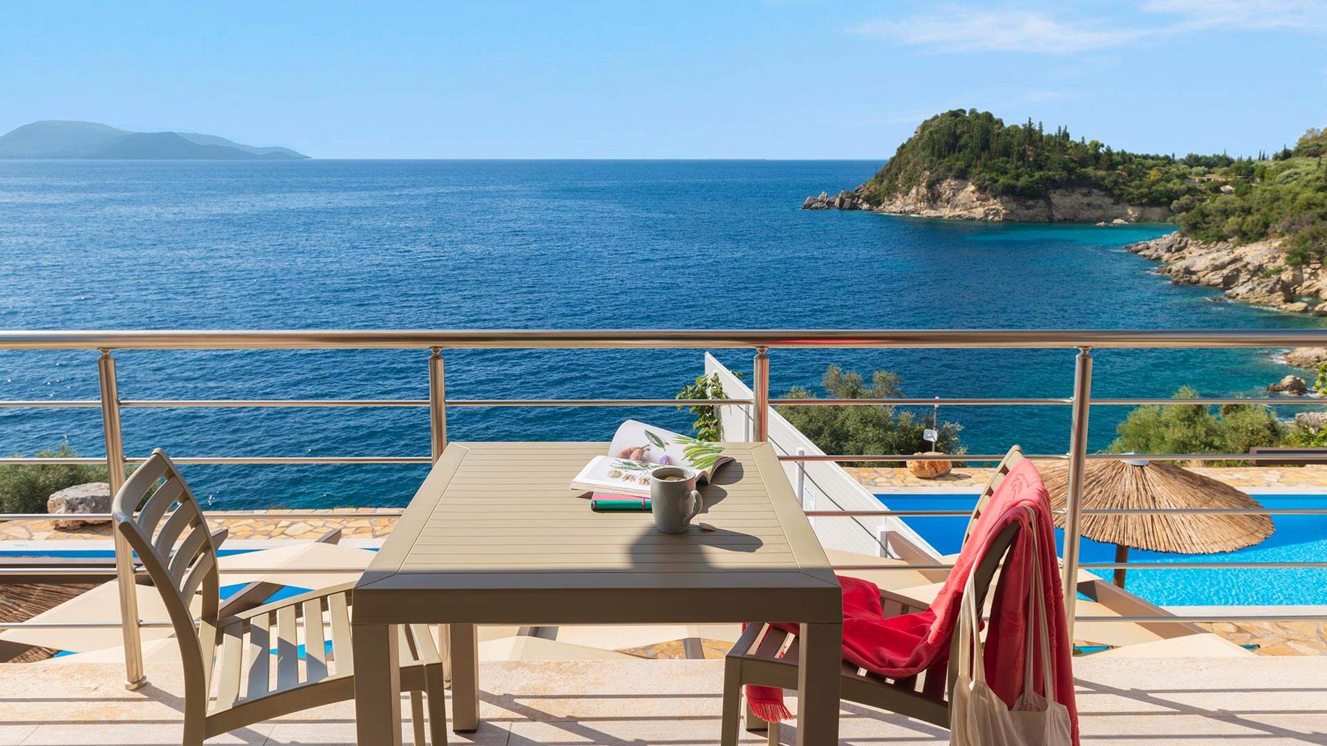 Tafeltje met twee stoeljes op terras met uitzicht over blauwe zee
