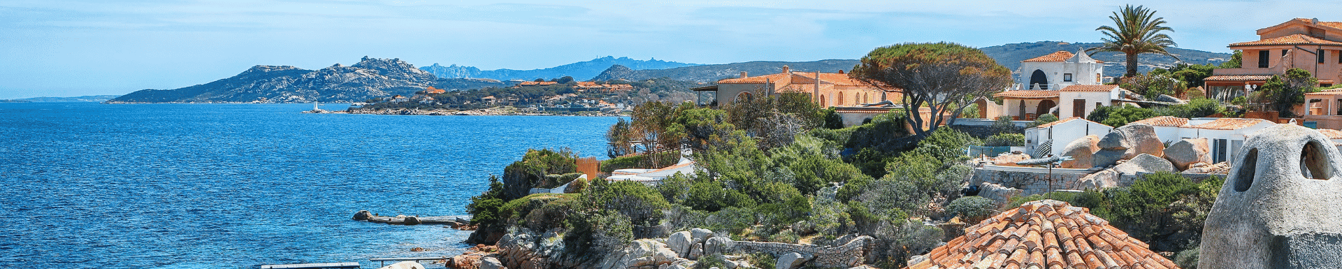 Heuvelachtige kust van Sardinië met villa's uitkijkend op het water