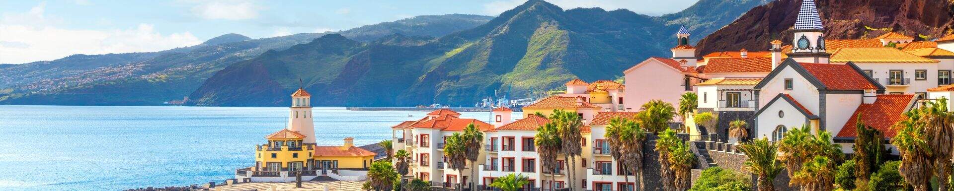 Dorpje met gekleurde huizen aan de kust van Madeira, met bergen op de achtergrond