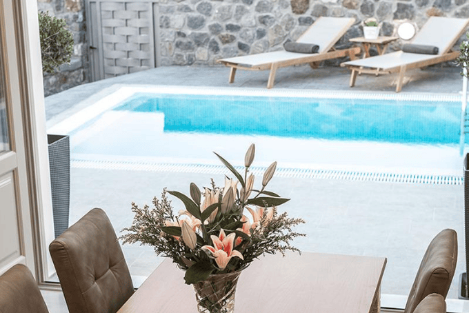 Tafel met uitzicht over privezwembad met ligstoelen